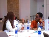 Two people having a conversation at a conference table.