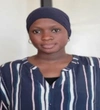 Aminta Faye in a blue and white striped button up shirt with a dark blue head wrap