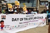 Group of people holding a large banner for the Day of the African Child