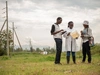 A group of scientists chatting in a field.