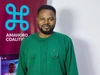 Agwu Kalu Ibe en tunique verte devant une affiche de la coalition Amahoro