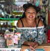 Woman smiling to camera leaning on a counter bar top