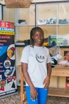 Martha standing in her graphic design and printing shop in Kakuma, Kenya