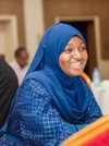 A young woman from the Mastercard Foundation Associates Program cohort 3 in Senegal smiling and wearing a blue dress and head covering.