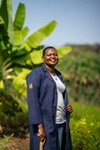 Naomi Eyeanae standing outdoors in a dark blue farming coverall