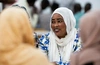 Lawyer Ameera Abdalla, 37, speaking with a group searing a white headscarf and a brightly patterned blue and white dress in Chad. © UNHCR/Ala Kheir