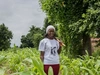 GRACE Program in partnership with the One Acre Fund, Hannatu standing outdoors in a lush farm setting.