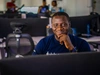 A young man sitting at a computer desk, smiling, Jobberman, Nigeria, 2024