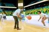 Two young people playing basketball in an arena 
