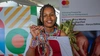 Young Kenyan woman entrepreneur showcasing her handmade crafts from her business.