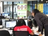 Two women working in an office at a desk, looking at a computer together, participants in the Skilling and Transitioning Youth into Global Business (GBS) Jobs Programme