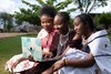 Three young women sitting outdoors working together on a laptop