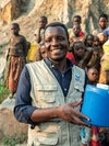 Oliver Nihimbazwe holding a container of fresh drinking water