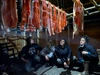 Yukon First Nations Climate Fellowship participants in the smoke shack with smoked salmon hanging