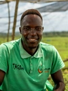 Anthony Emaru wearing a bright green collared shirt and smiling