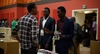 Three men standing around a table