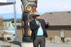 Man stood outside by a building talking into a microphone 