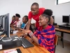 Two young people working at a computer station together.