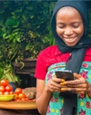 Woman smiling and working on her mobile device.