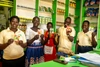 Gordon Victor standing in a shop with a group holding packets of seeds