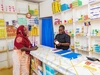 Victoria, helping a client behind the counter at her healthcare clinic, in Gurei, South Sudan 2026.