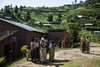 People standing in small groups in their village.