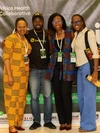 A group of people standing in front of the Africa Health Collaborative poster in 2024