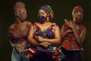 Three women posing in matching garments and fabric face masks