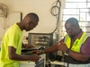 Vasco Hamisi working with one of his electricity clients, Kakuma refugee camp, 2025, 4 x 3