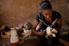 A woman vaccinating a young chicken.