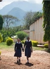 Two schoolgirls walking through the school grounds.