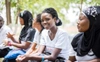 A row of young female Scholar applicants sitting outside.