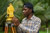 Easu Higenyi working outdoors doing surveying work.