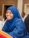 A young woman from the Mastercard Foundation Associates Program cohort 3 in Senegal smiling and wearing a blue dress and head covering.