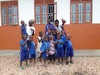 Vanessa Ishimwe with a group of young children in casual blue uniforms