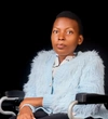 Marie Aimee Dukuze wearing a light blue long haired cardigan, with a white collared shirt underneath