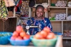 Christine Atenge sat smiling to camera with a sewing machine in front of her