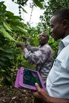 Two men outside, one holding a tablet.