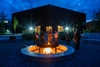 People standing around an outdoor fire at dusk.