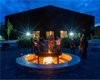 A group of people at dusk enjoying a fire