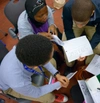 A Birdseye view down on a small group of students talking and holding papers