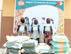 Three people stood behind multiple bags of seed