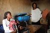 Delphine, right, and Angelique, left, take a moment to speak with visitors to the anti-violence tailoring shop led by Tamari.