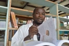 Man looks to camera with a book on the table in front on him