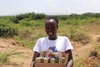 Lucia outdoors holding a box of canned goods
