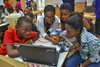 A group of people gathered around a laptop