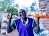 Gloria Dawa in a blue vest displaying some of her pastries