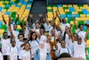 Group of Mastercard Foundation Scholars celebrating at the Baobab summit 2022 in an arena wearing branded Scholars @10 white tshirts