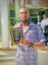 Lincoln Olatunji proudly grasping an award as one of the winners of the 2023 Social Venture Challenge