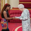 Queen Elizabeth 2 of England holds hands with Nonduduzo Ndlovu